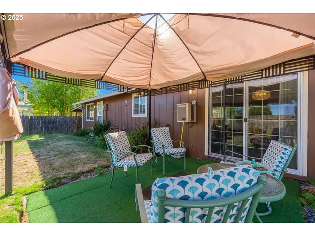 a backyard of a house with table and chairs
