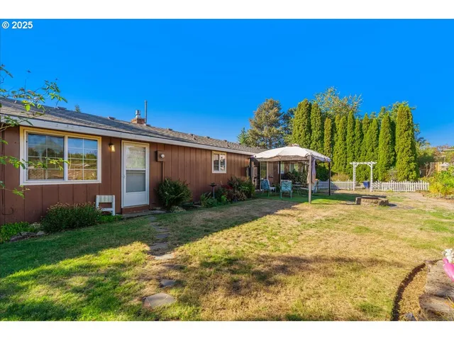 a view of a house with backyard and sitting area