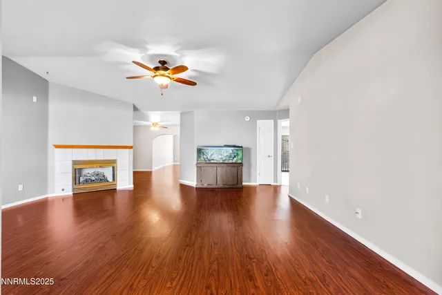 a view of an empty room with window and wooden floor