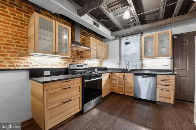a kitchen with granite countertop a sink cabinets and stainless steel appliances