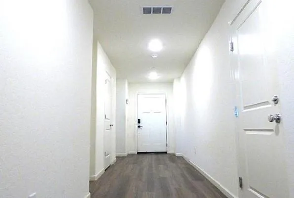 a view of a hallway with wooden floor