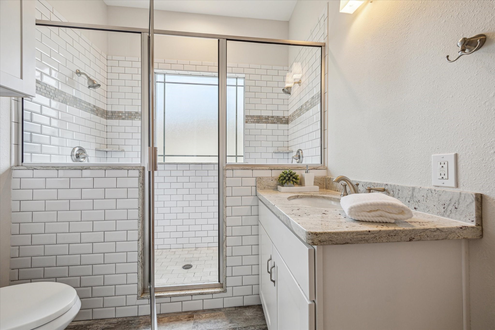 1833 Tabor Street Houston, TX 77009 - Photo 18 of 28 Guest bathroom located between the secondary bedrooms, featuring a sleek double shower with glass door and classic subway tile