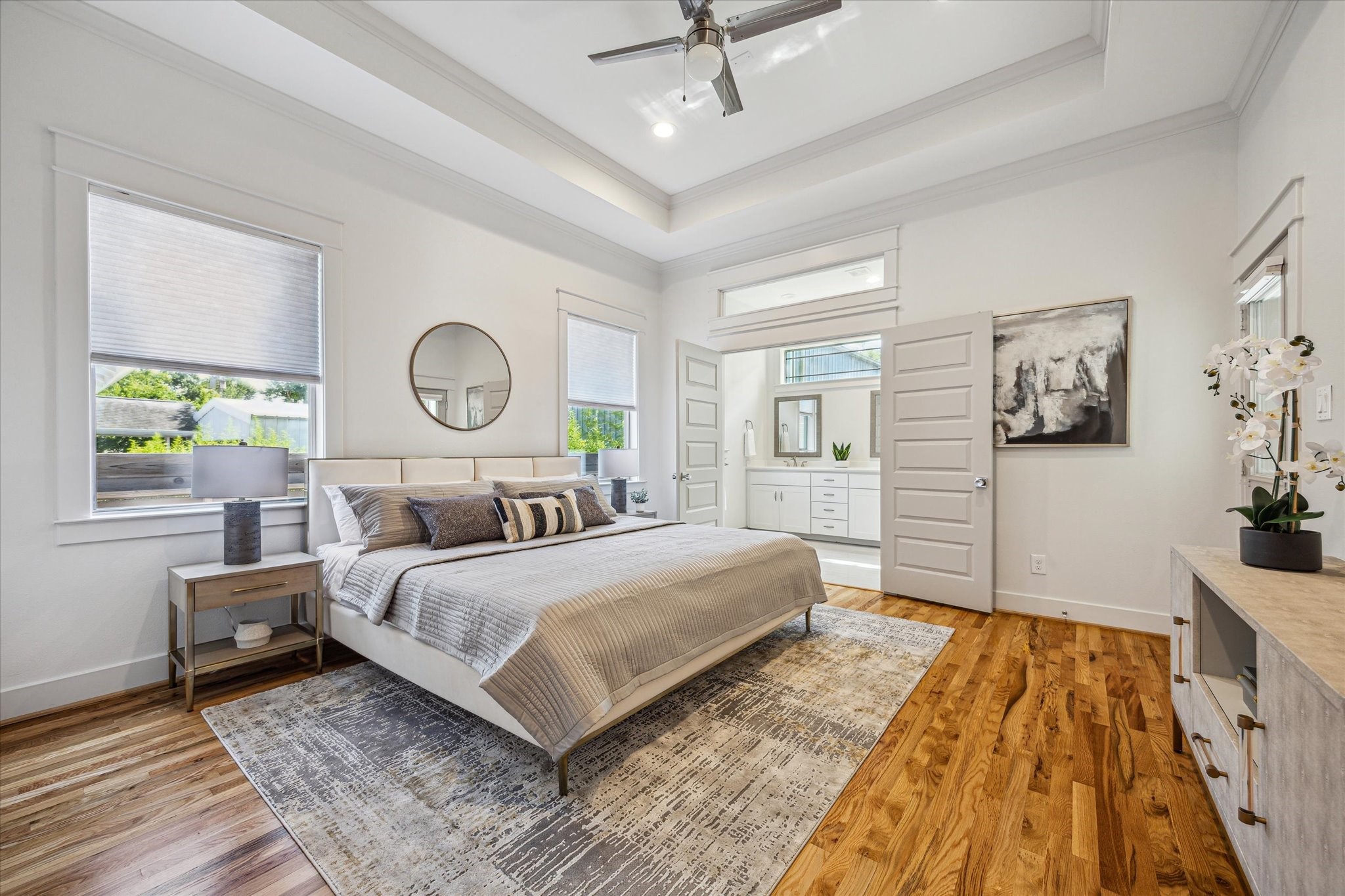 1833 Tabor Street Houston, TX 77009 - Photo 20 of 28 Serene primary suite with tray ceilings, abundant natural light, and direct access to the ensuite bath - your perfect retreat at the end of the day.