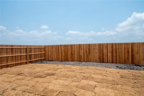 a view of backyard with wooden fence