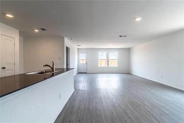 a view of a big room with wooden floor and windows