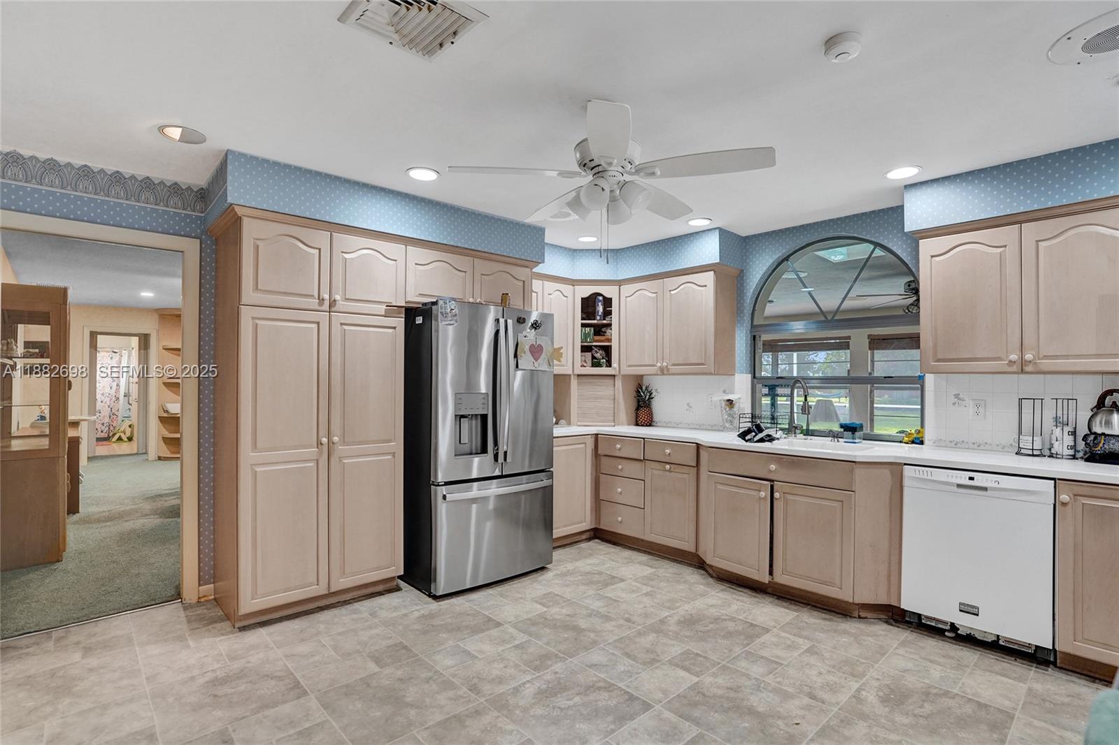 1021 Grandview Boulevard Fort Pierce, FL 34982 - Photo 15 of 34 a kitchen with white cabinets and stainless steel appliances