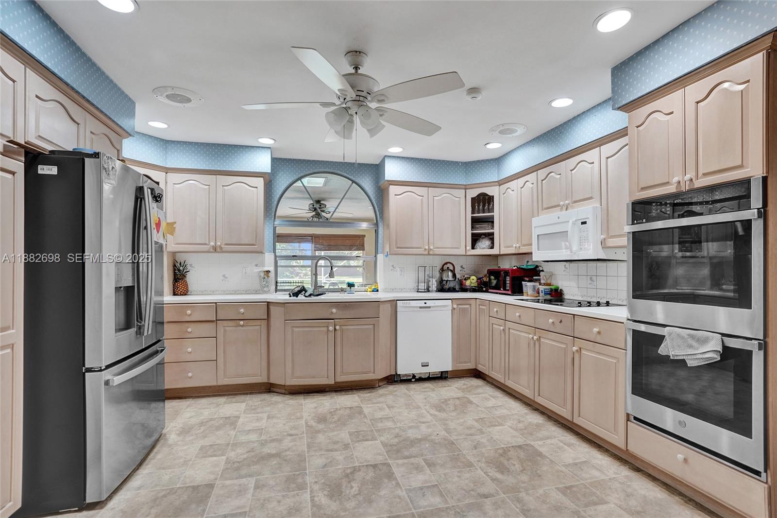 1021 Grandview Boulevard Fort Pierce, FL 34982 - Photo 16 of 34 a kitchen with white cabinets and white appliances