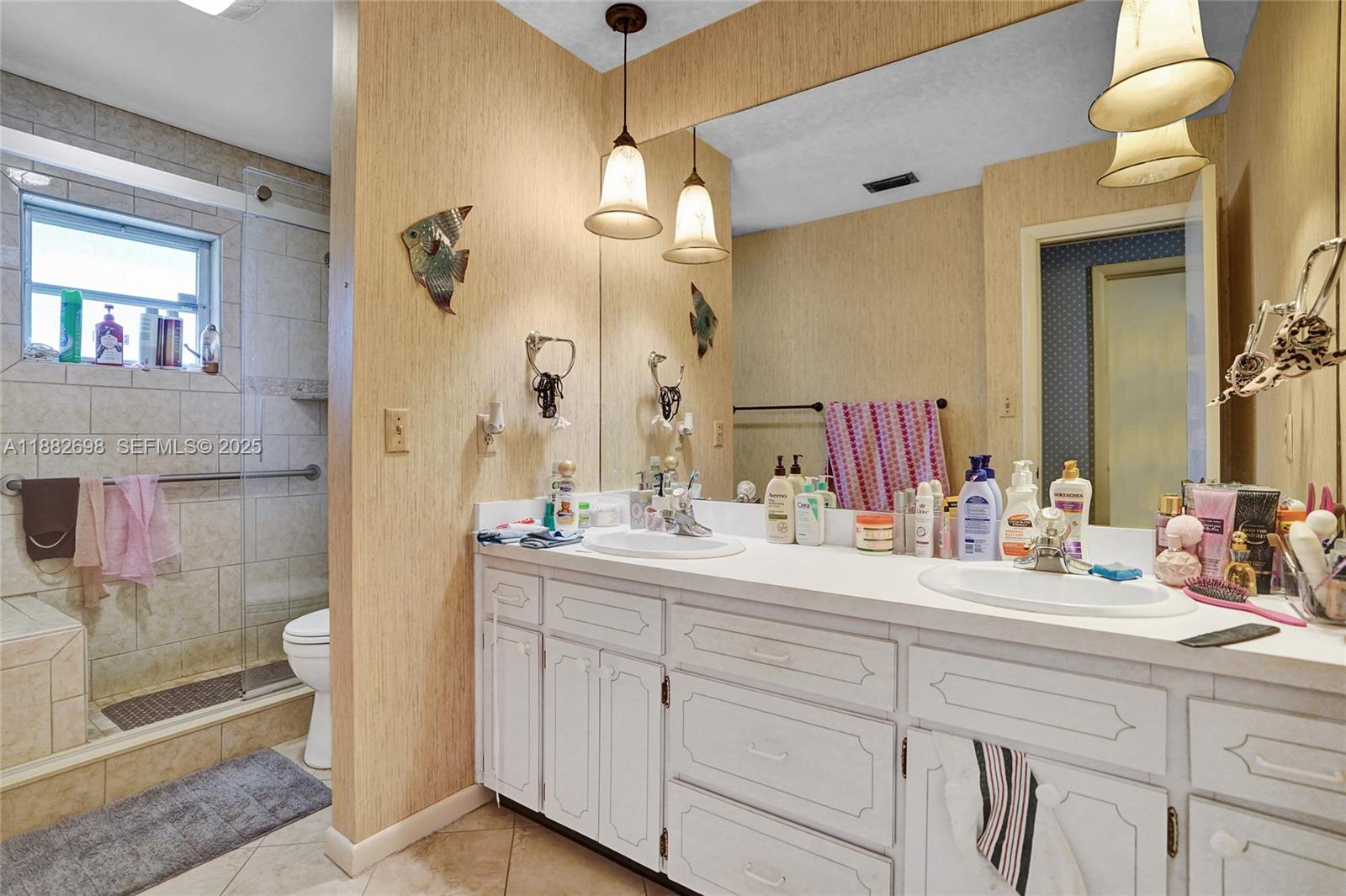 1021 Grandview Boulevard Fort Pierce, FL 34982 - Photo 17 of 34 a bathroom with a double vanity sink mirror and shower