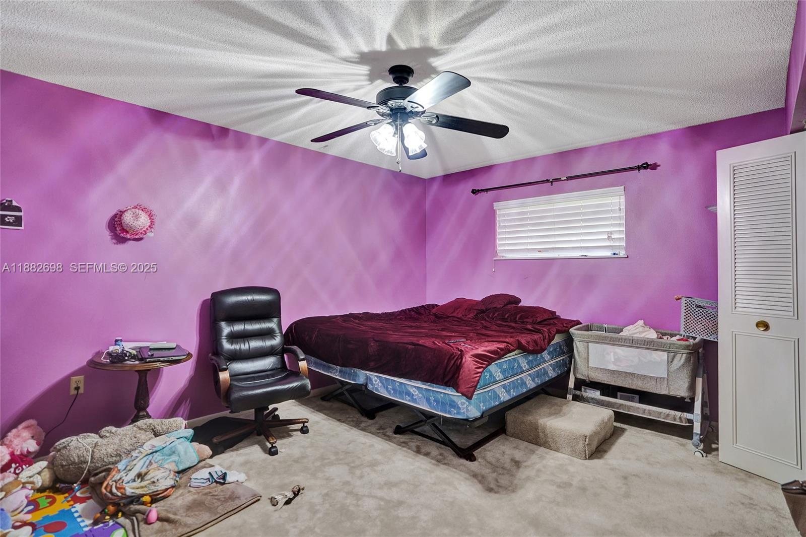 1021 Grandview Boulevard Fort Pierce, FL 34982 - Photo 19 of 34 a spacious bedroom with a bed dresser and a chandelier