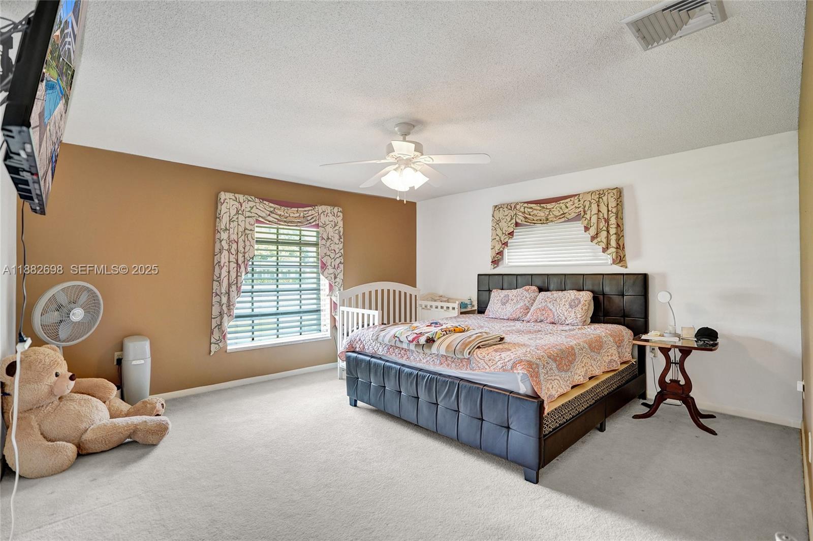 1021 Grandview Boulevard Fort Pierce, FL 34982 - Photo 6 of 34 a bedroom with a bed and a chandelier