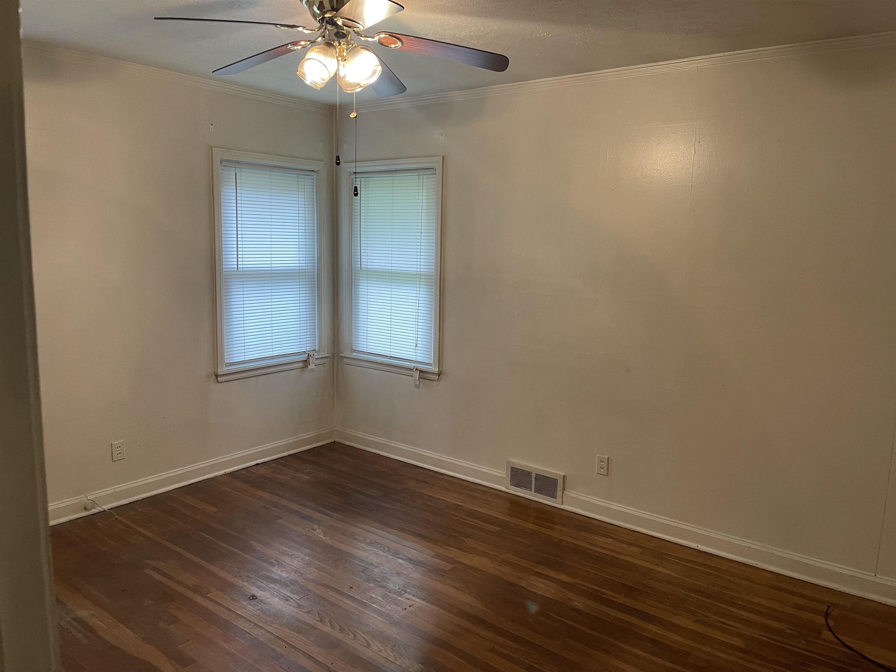 895 Enfield Road Memphis, TN 38116 - Photo 5 of 9 an empty room with wooden floor and windows