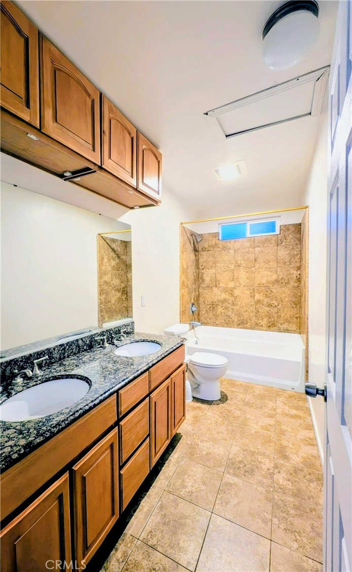 363 Ford Road Sacramento, CA 95838 - Photo 16 of 23 a bathroom with a granite countertop sink a toilet and bathtub