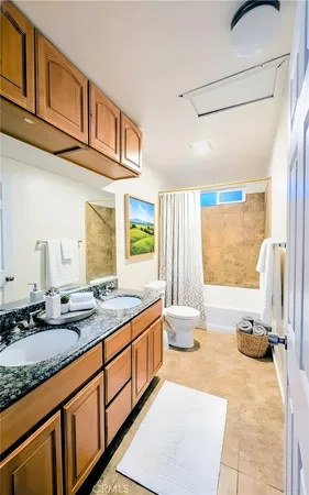 a bathroom with a granite countertop sink a mirror and a bathtub