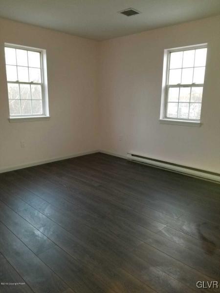 134 Ryan Road Blakeslee, PA 18610 - Photo 24 of 33 an empty room with wooden floor and windows