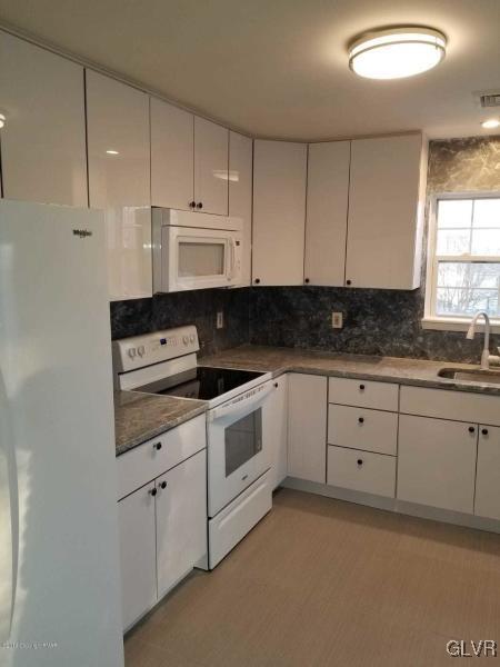 134 Ryan Road Blakeslee, PA 18610 - Photo 4 of 33 a kitchen with granite countertop white cabinets and white appliances