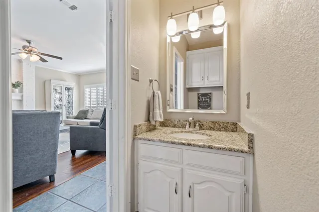 a en suite bathroom with a granite countertop sink and a mirror