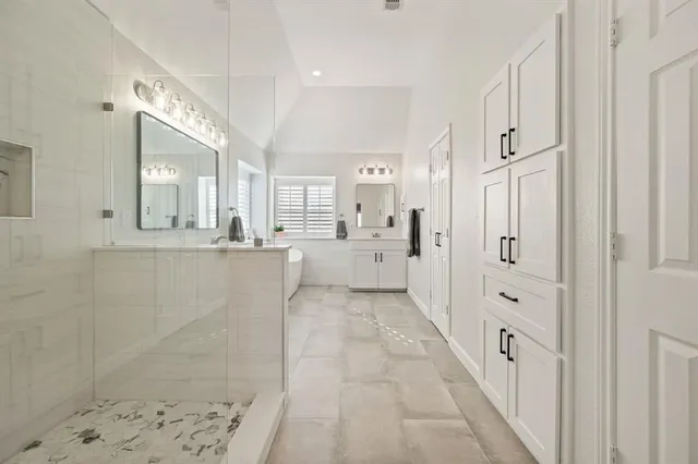 a large white bathroom with a large mirror