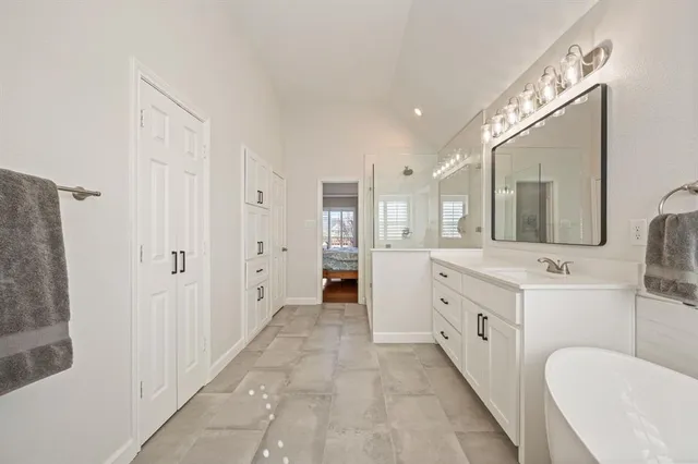 a spacious bathroom with a double vanity sink a mirror and a shower
