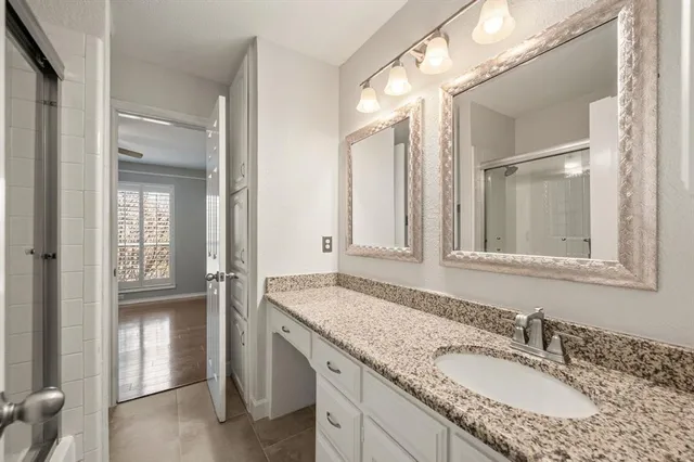 a bathroom with a granite countertop sink and a mirror