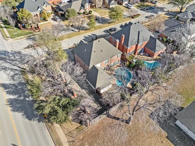 an aerial view of a house with a yard and large trees