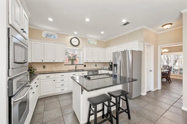 a kitchen with stainless steel appliances granite countertop a refrigerator and a stove top oven