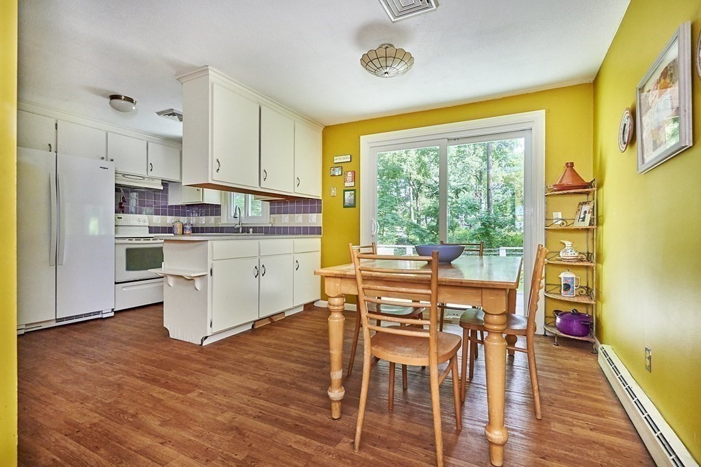 1021 Burts Pit Road Northampton, MA 01062 - Photo 11 of 33 a kitchen with stainless steel appliances granite countertop a stove a refrigerator a microwave oven with a dining table and chairs with wooden floor