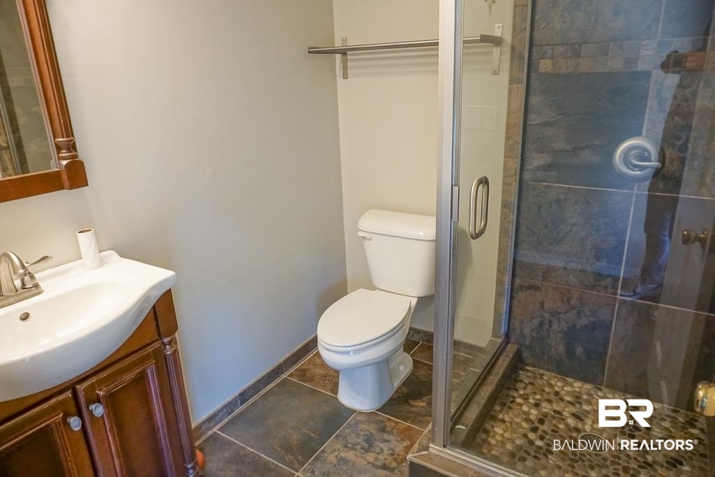 255 Suffolk Road Mobile, AL 36608 - Photo 22 of 29 Bathroom featuring vanity, a stall shower, and dark tile patterned flooring
