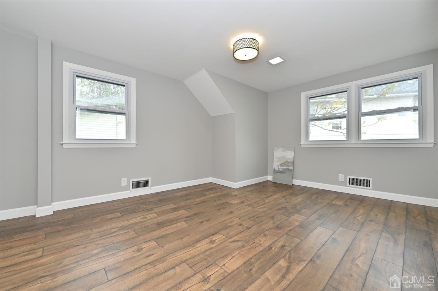 383 Paterson Avenue East Rutherford, NJ 07073 - Photo 11 of 21 an empty room with wooden floor and windows