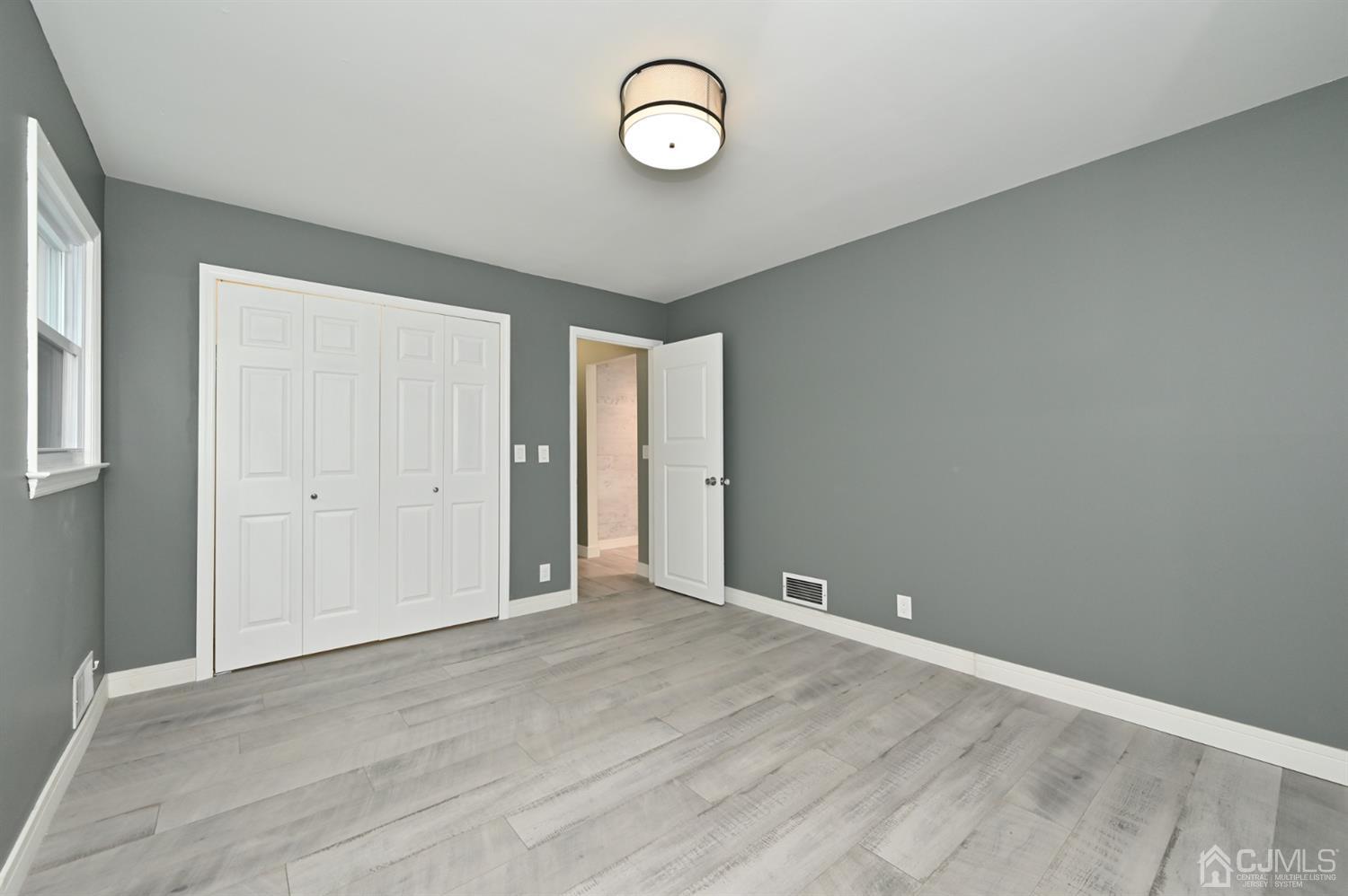 383 Paterson Avenue East Rutherford, NJ 07073 - Photo 15 of 21 a view of an empty room with wooden floor and window