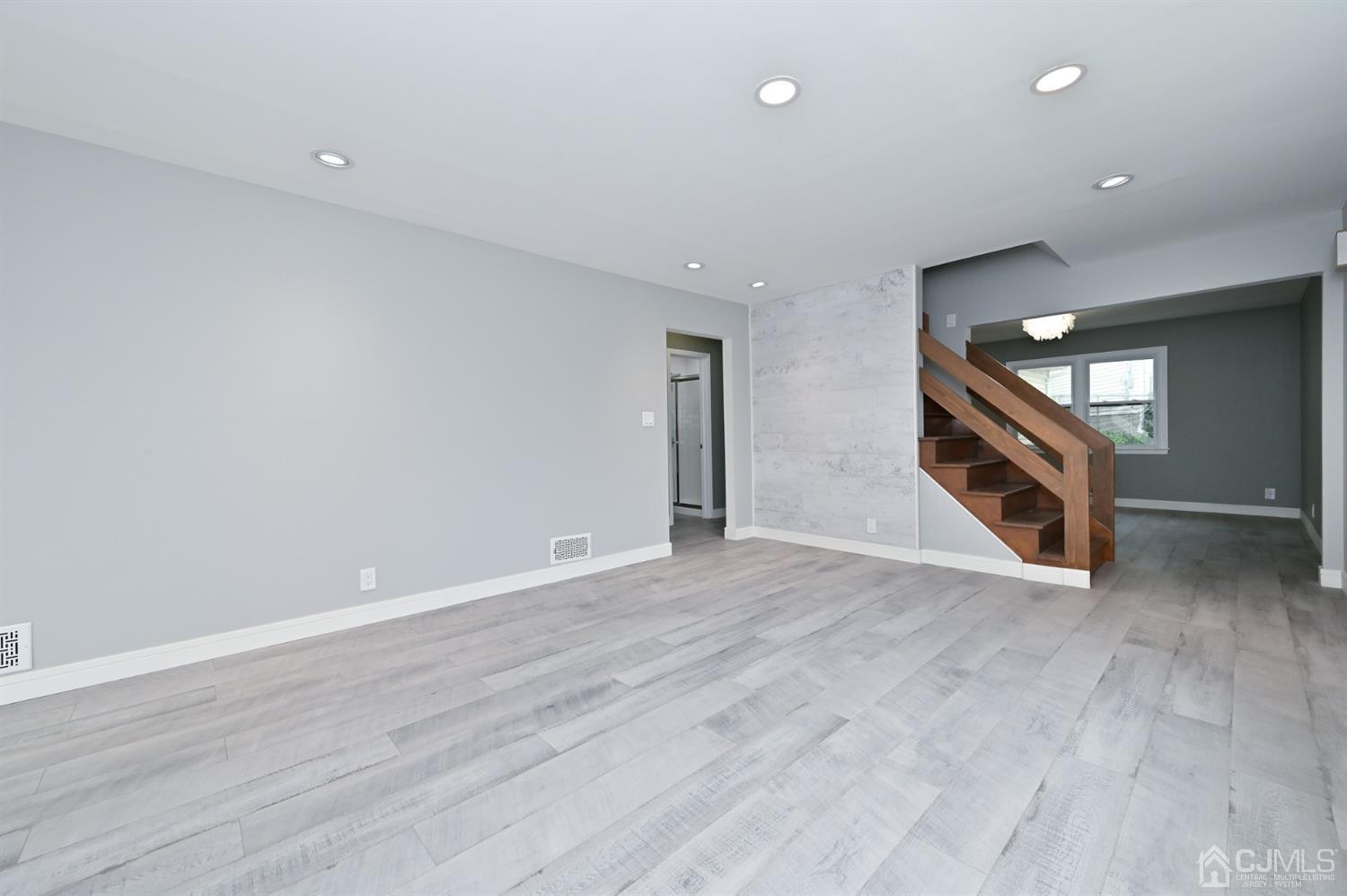 383 Paterson Avenue East Rutherford, NJ 07073 - Photo 3 of 21 a view of an empty room with wooden floor and a window