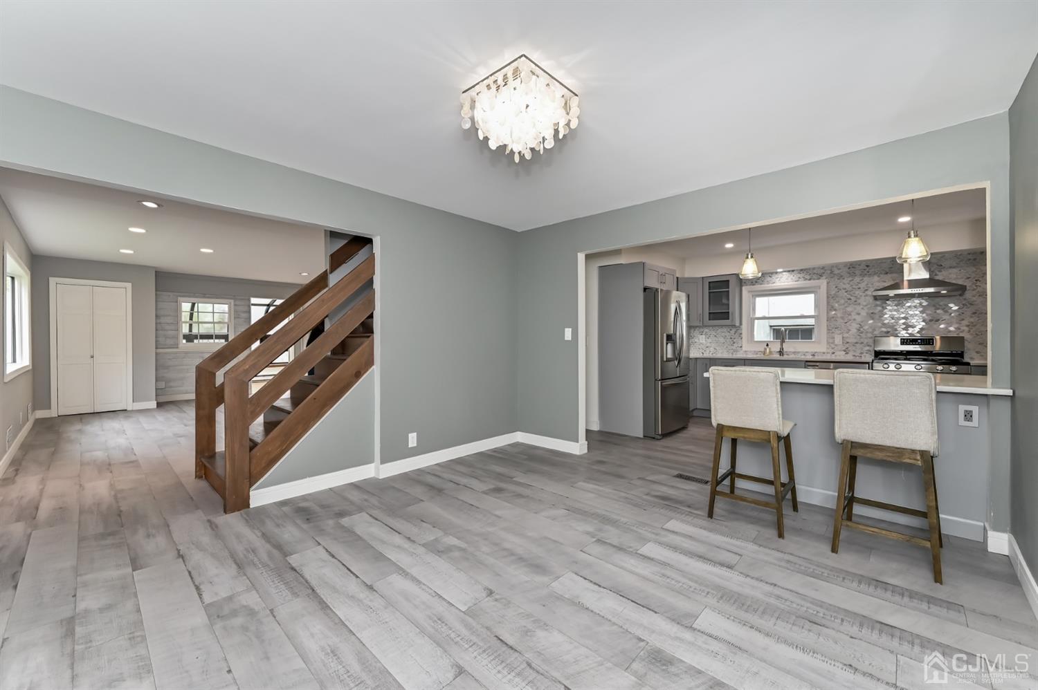 383 Paterson Avenue East Rutherford, NJ 07073 - Photo 4 of 21 a view of a hallway with wooden floor and a chandelier