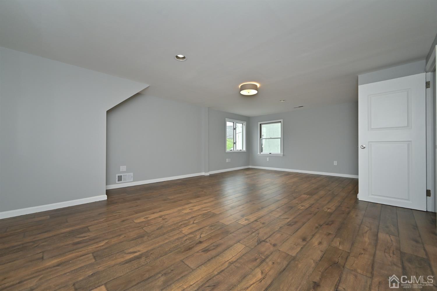 383 Paterson Avenue East Rutherford, NJ 07073 - Photo 5 of 21 an empty room with wooden floor and windows