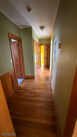 a view of a hallway with wooden floor and stairs