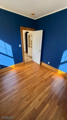 a view of a big room with wooden floor and windows