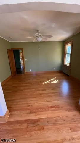 a view of empty room with window and wooden floor