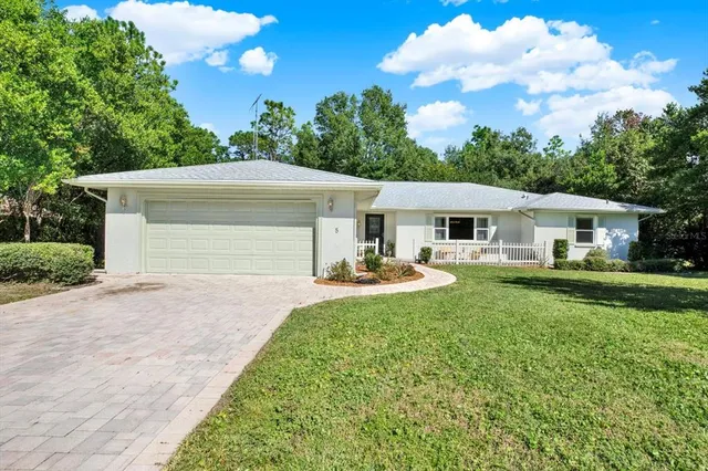 a front view of a house with yard patio and green space