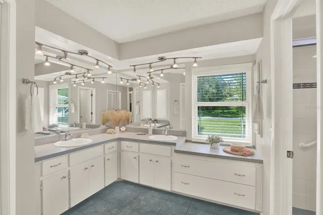 a bathroom with a granite countertop sink mirror and next to a window
