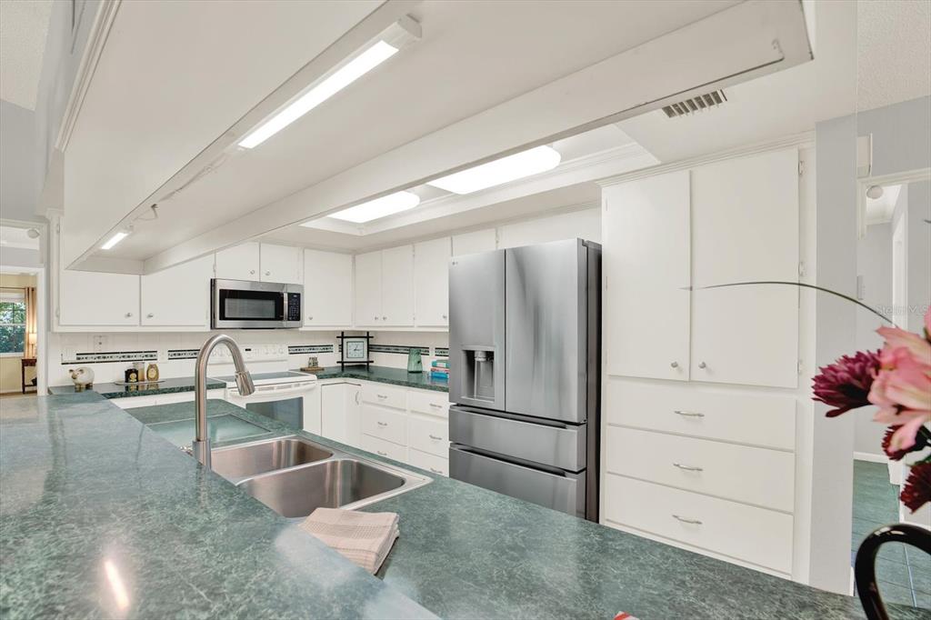 5 Balsam Court South Homosassa, FL 34446 - Photo 3 of 35 a kitchen with white cabinets and stainless steel appliances