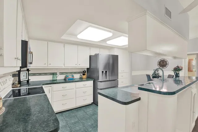 a kitchen with granite countertop a sink a stove and refrigerator