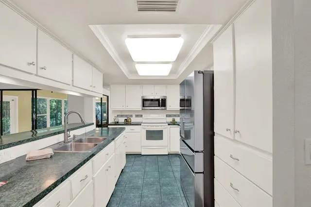 a large kitchen with a large window and stainless steel appliances