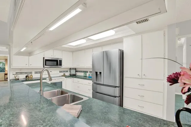 a kitchen with white cabinets and stainless steel appliances