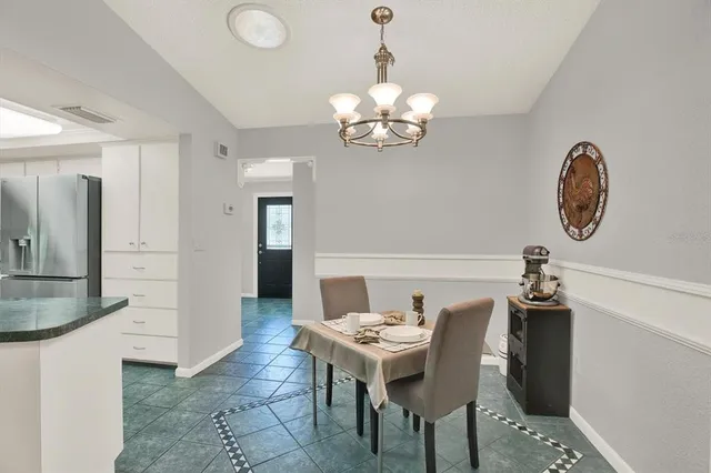a view of a dining room with furniture and chandelier