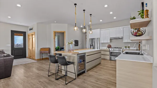 a kitchen with a sink and chairs
