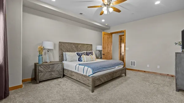 a spacious bedroom with a bed and a chandelier