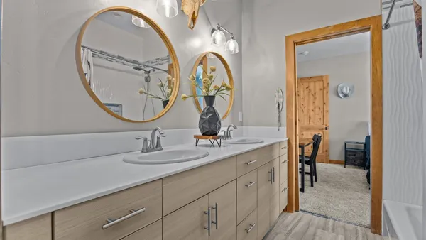 a en suite bathroom with a granite countertop double vanity sink and a mirror