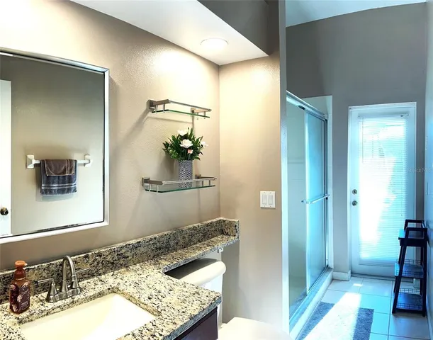 a bathroom with a granite countertop sink and a mirror