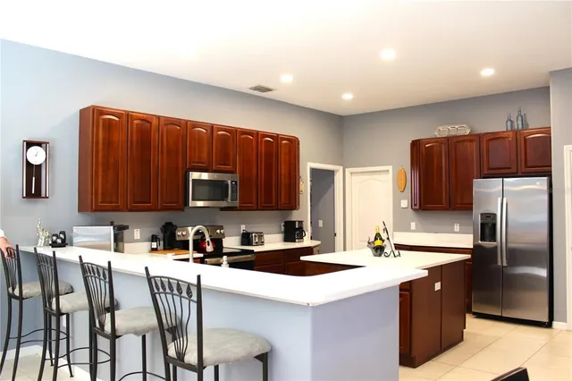a kitchen with stainless steel appliances granite countertop a sink refrigerator and microwave