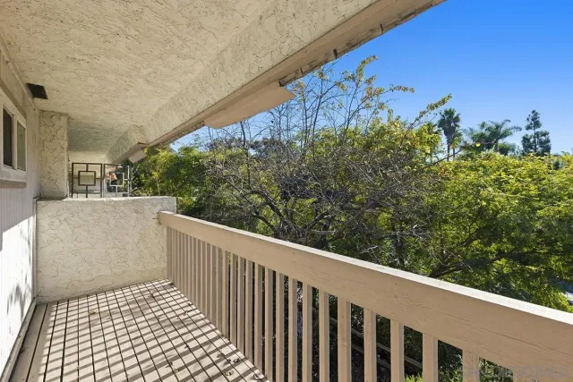 a view of a balcony with wooden fence and floor