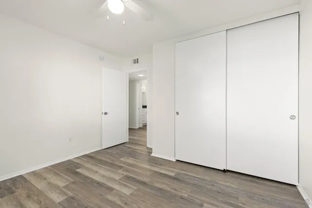 a view of an empty room with wooden floor