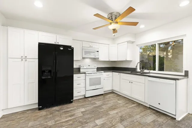 a kitchen with a refrigerator and a white cabinets